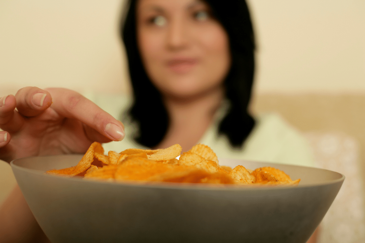 Vrouw eet 's avonds laat chips