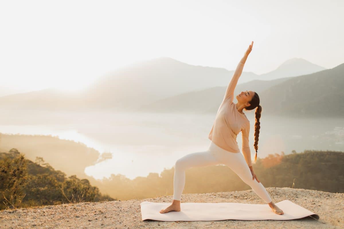 Sportive Woman Exercising Outdoors And Practicing Yoga Asanas At Sunrise With Amazing Mountain View