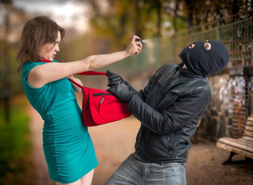 Self Defense Concept. Young Woman Is Using Pepper Spray. Zelfverdediging, pepperspray