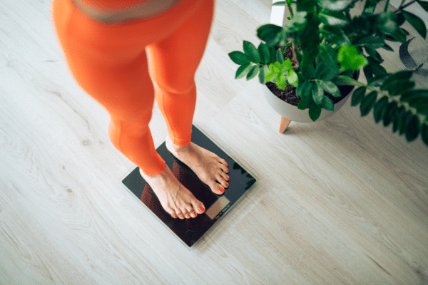 vrouw staat op weegschaal voor gewicht