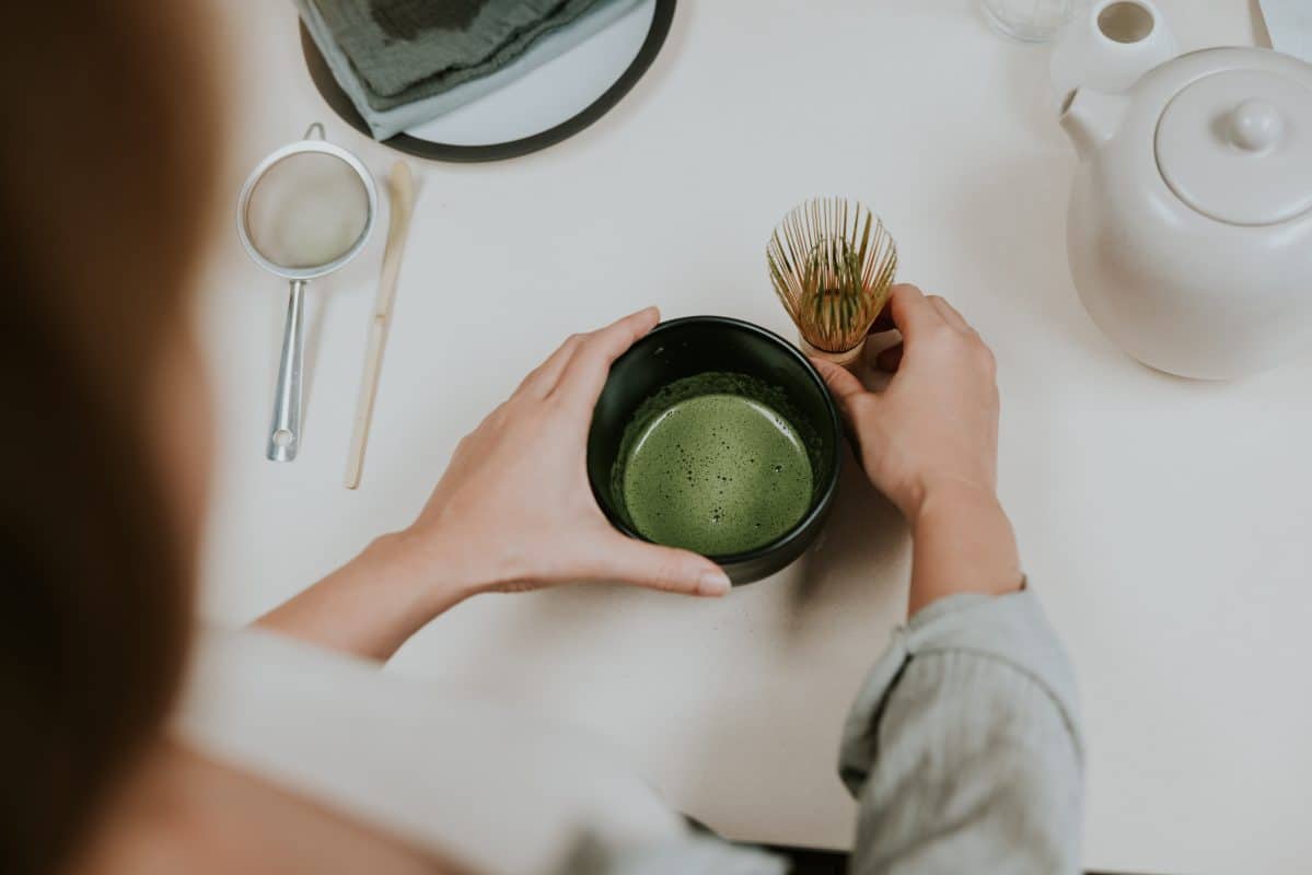 Woman Hand Making Organic Green Matcha With Bamboo.