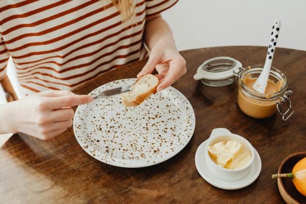 Vrouw smeert boter Op Brood