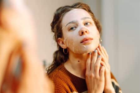 Vrouw doet gezichtsmasker op - sunday reset