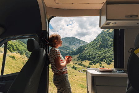 Vrouw is aan het kamperen en staat in camper