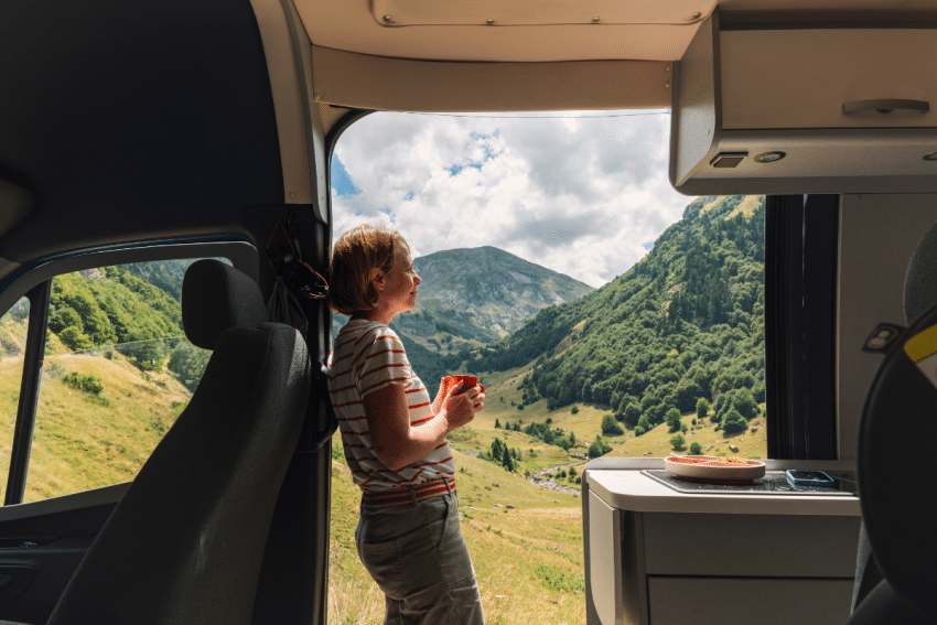 Vrouw is aan het kamperen en staat in camper