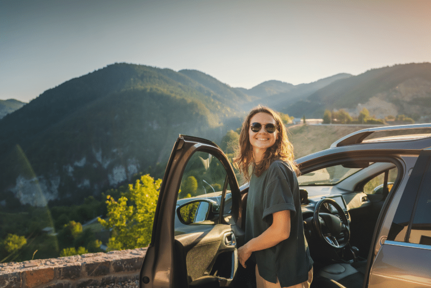 Vrouw rijdt met auto in zomer