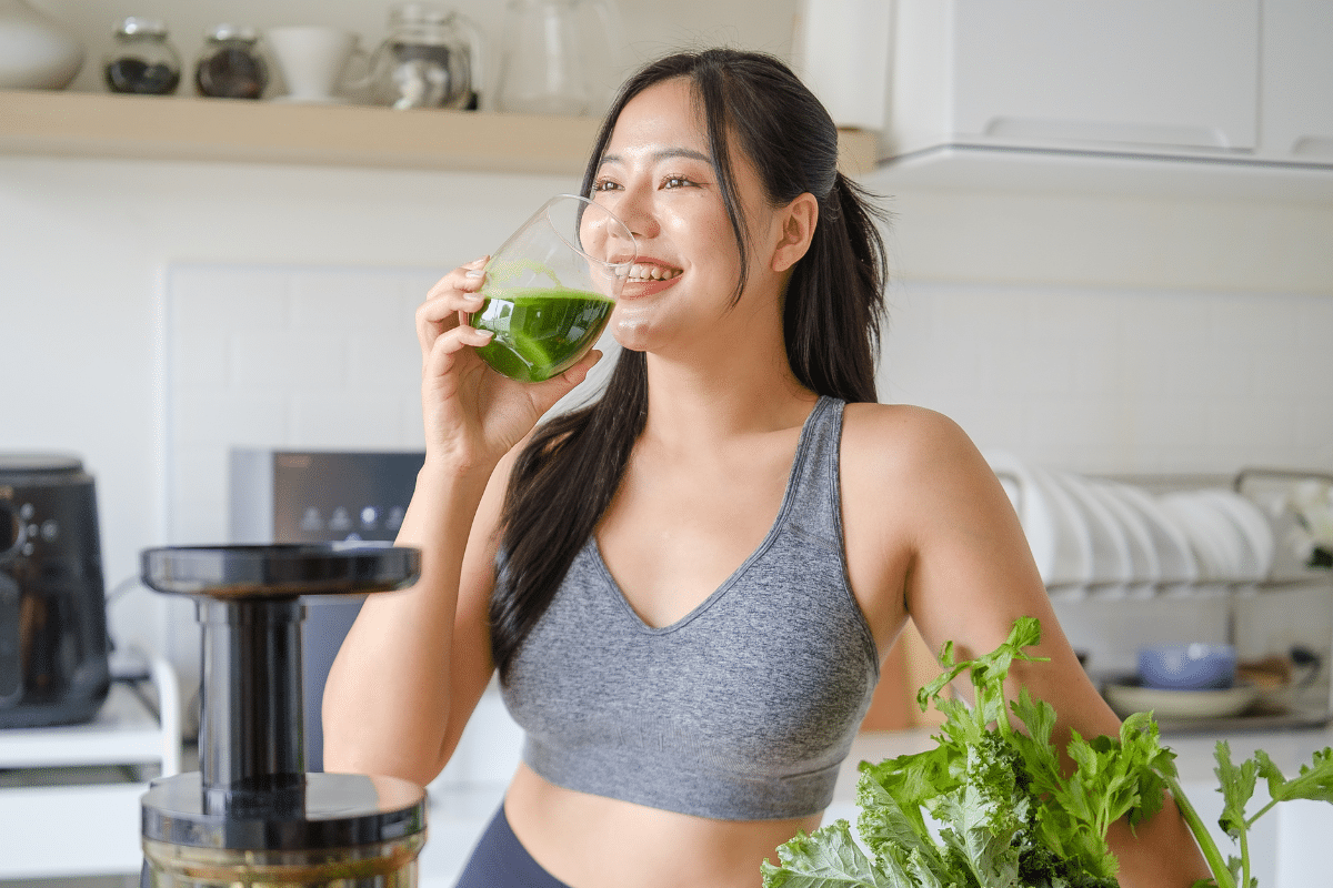 Vrouw drinkt sap uit slow juicer