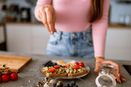 Vrouw strooit zout over eten
