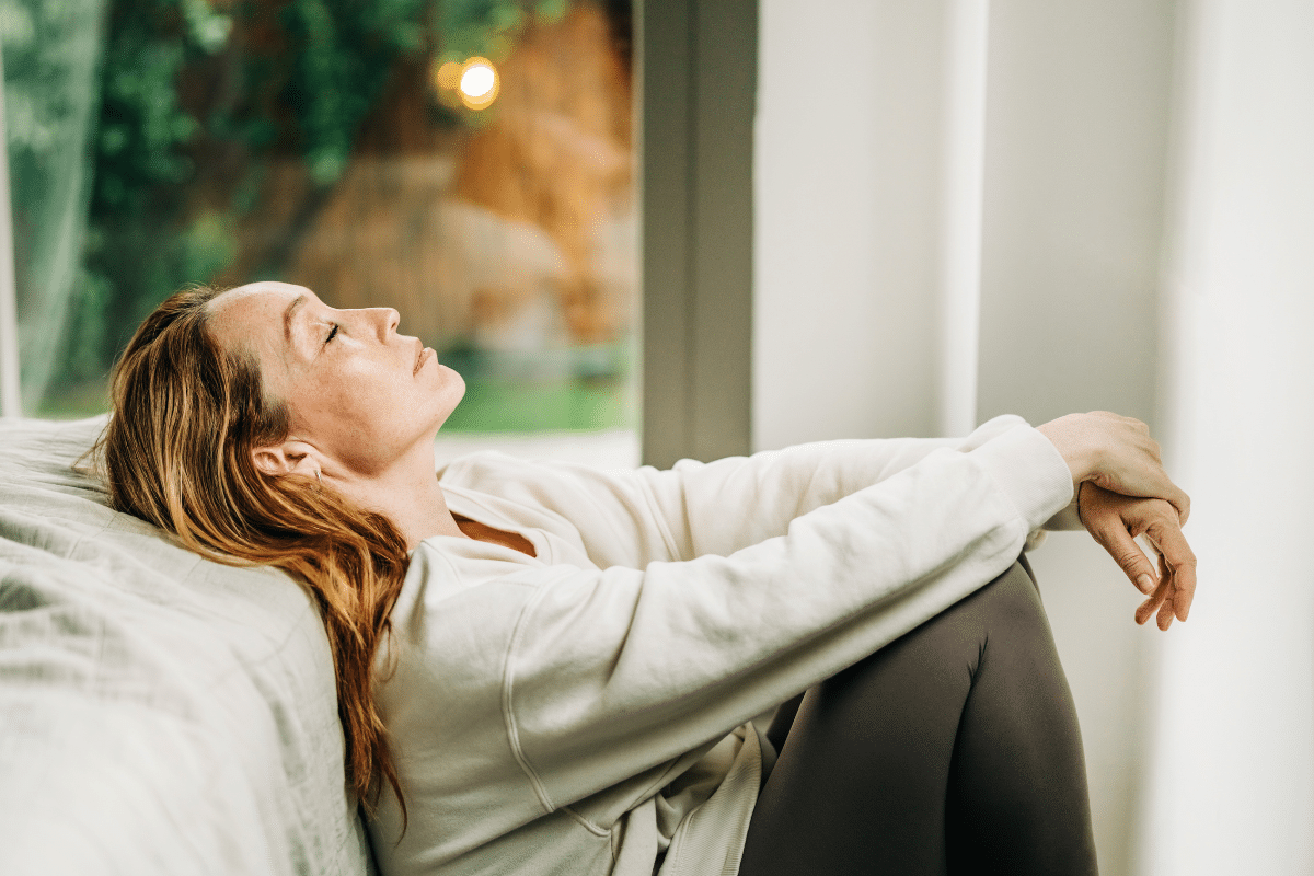 Vrouw zit verdrietig op de bank