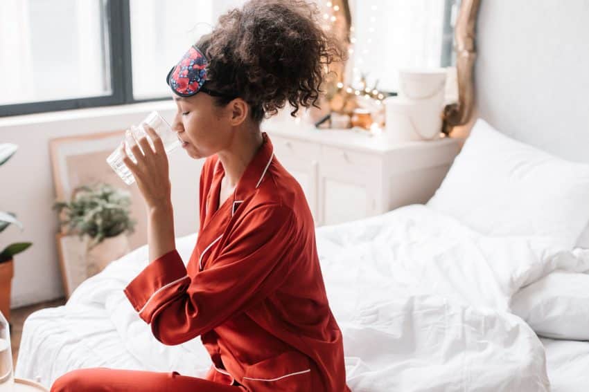 Vrouw Drinkt Water Op Bed