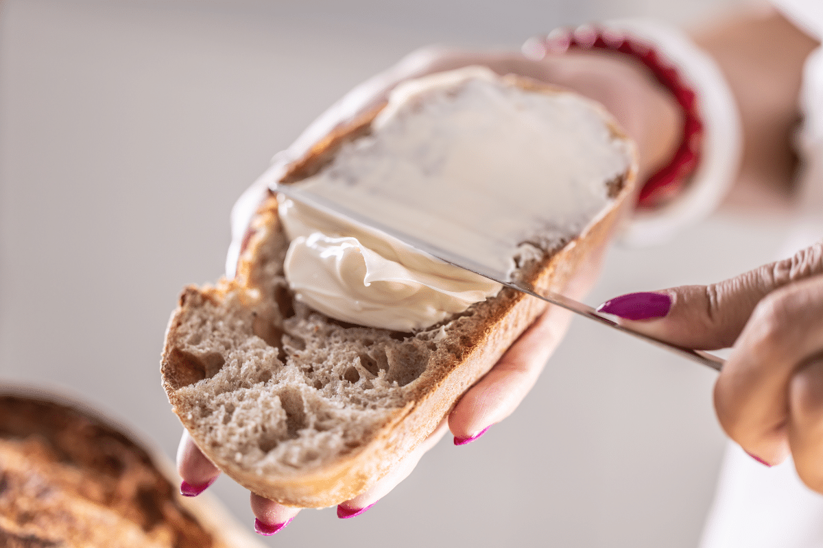 Vrouw smeert boter op brood