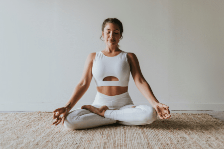 Vrouw zit in yogahouding