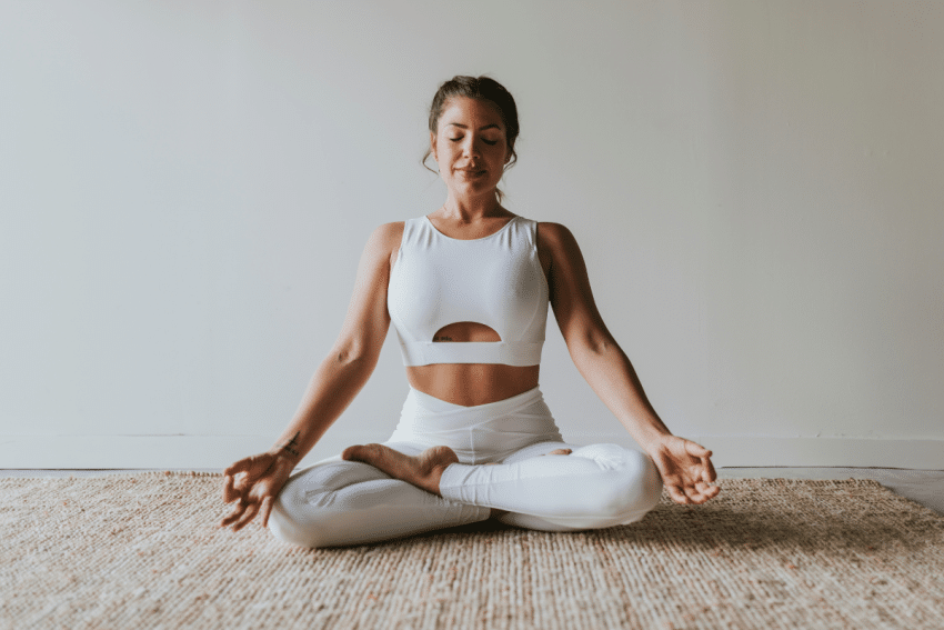Vrouw zit in yogahouding
