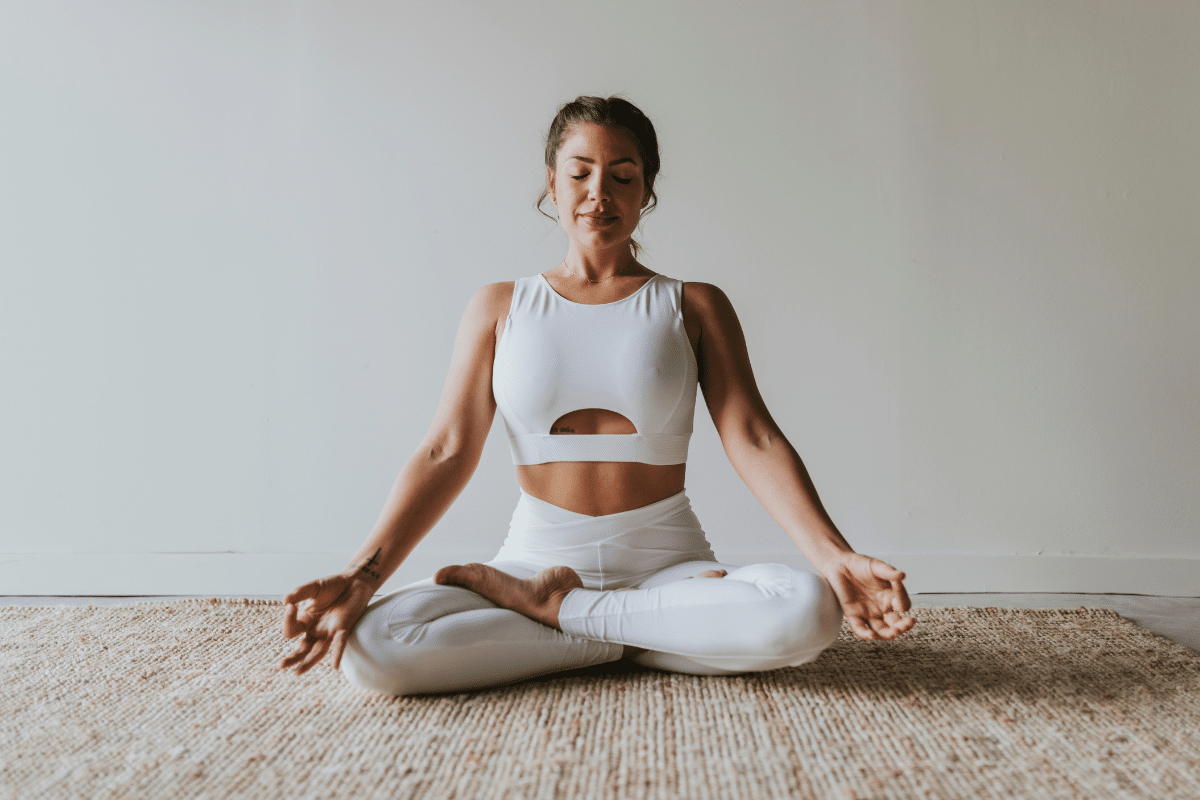 Vrouw zit in yogahouding