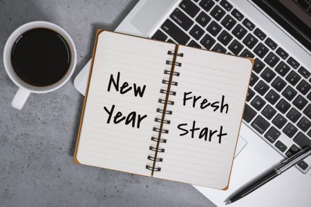 New Year Fresh Start On Notebook With Laptop Over Work Desk
